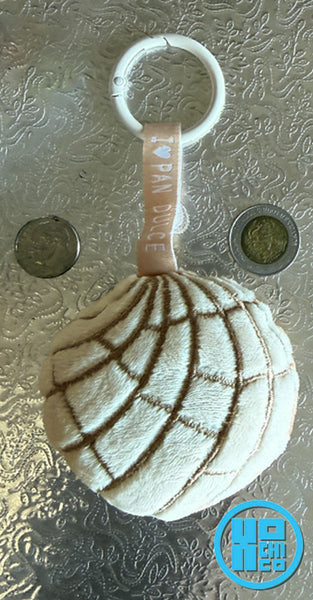 Plush vanilla concha key chain with ribbon and carabiner clip.