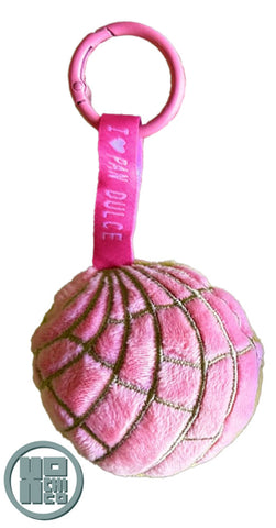 Plush concha key chain with ribbon and carabiner clip. Strawberry color.